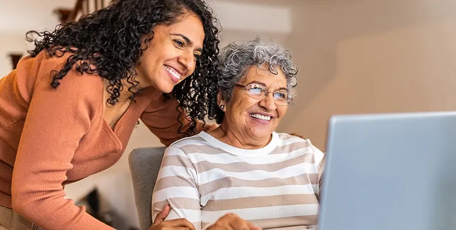 Daughter helping her mother on a computer