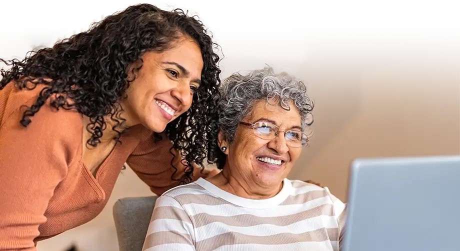 Daughter helping her mother on a computer