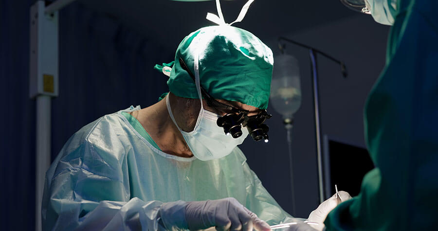 Physician in surgery wearing medical magnifying glasses